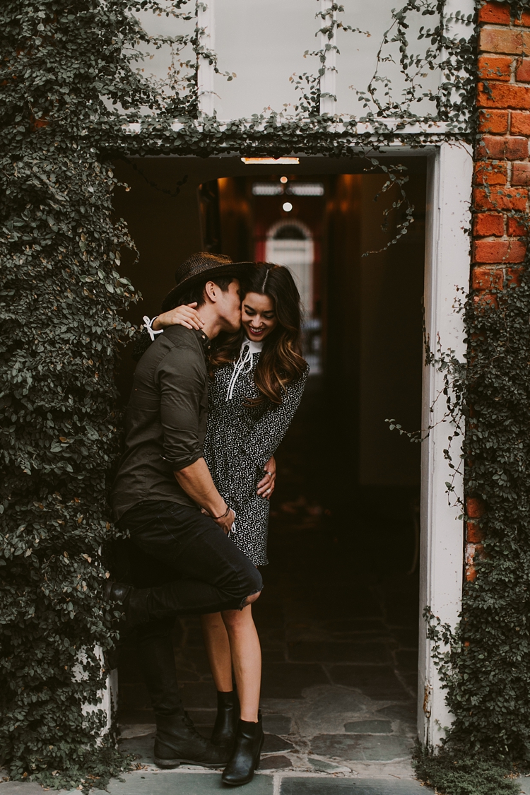 Engaged couple kissing in courtyard of New Orleans French Quarter