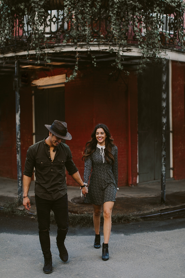 Engaged couple laughing in the streets of New Orleans crossing the street