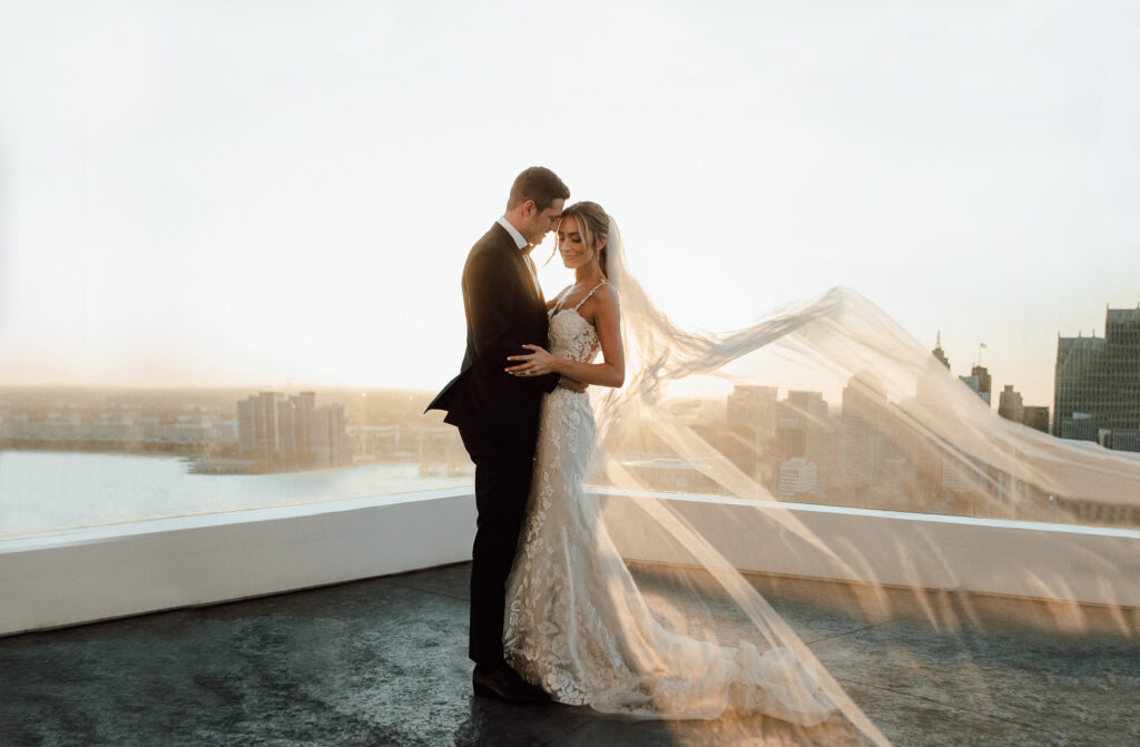 bride and groom kissing at sunset on rooftop wedding