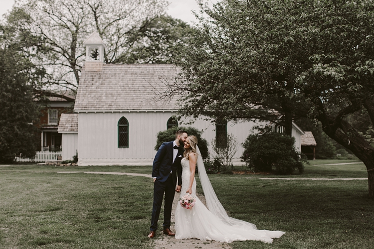 Couple kiss outside of chapel at Balls Falls