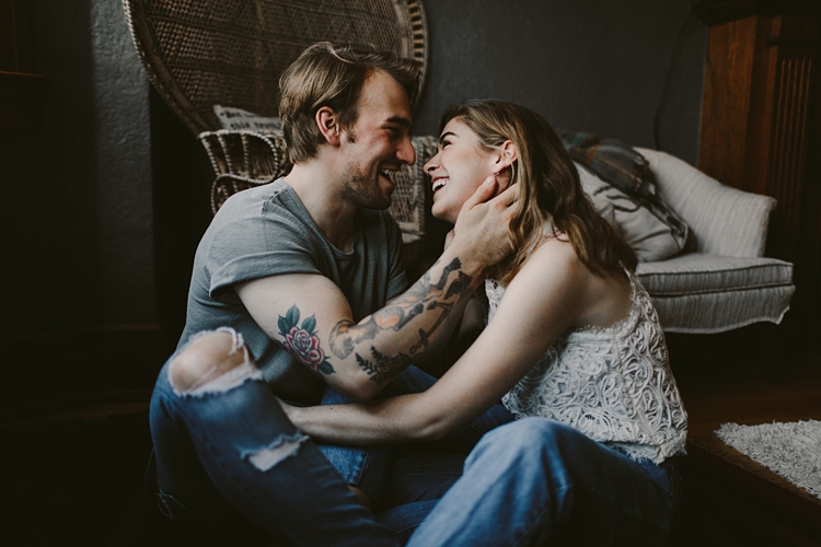 Couple laugh and embrace in their living room