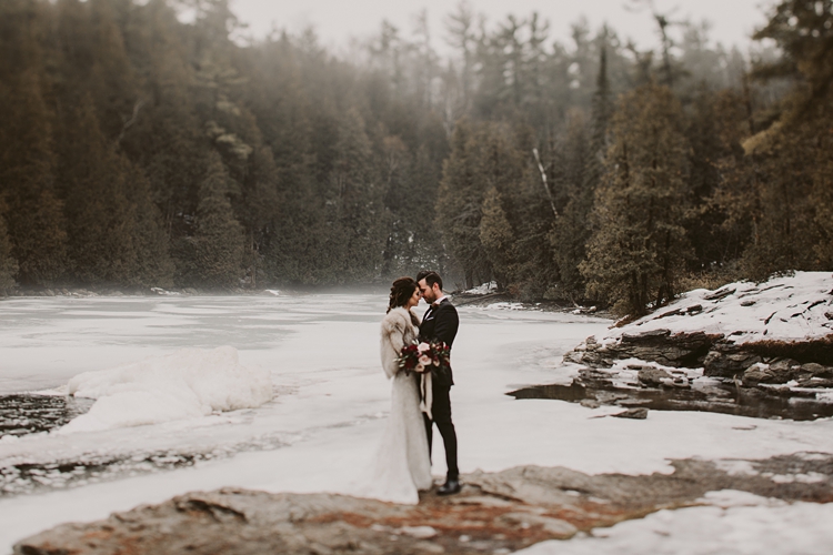 Bride wearing fur kisses her groom in the fog in Toronto
